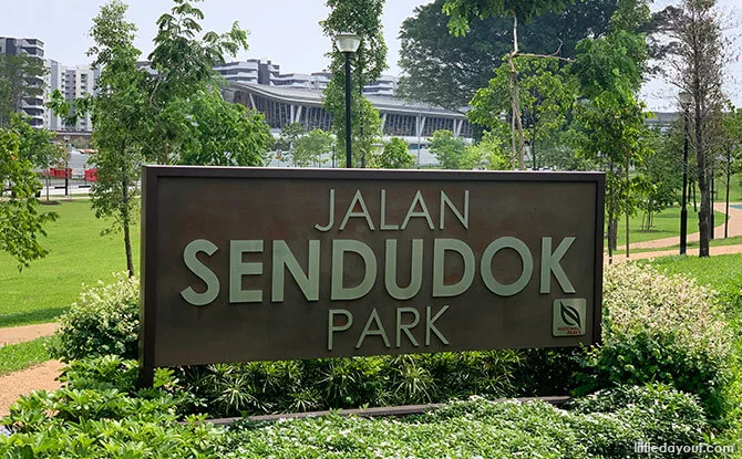 Jalan Sendudok Park entrance sign with lawns and trees, next to the Canberra Drive EC site in Sembawang